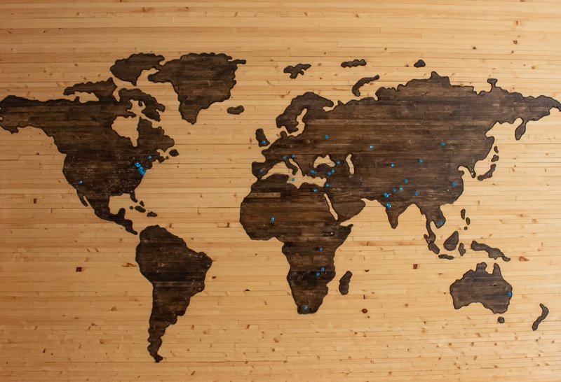 Wooden map of the world with pins